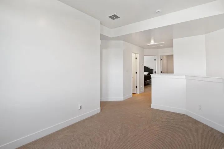 Carpeted open area with white walls and trim