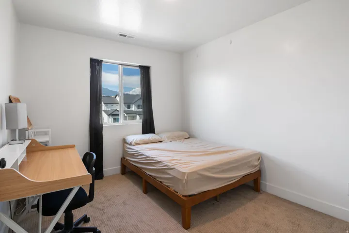 Bright room featuring a large window, neutral carpet, white baseboards, and a white ceiling