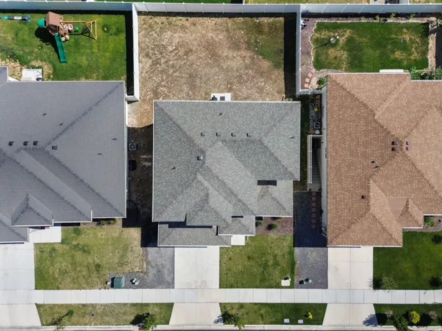 Residential property with a gray shingle roof and a concrete driveway