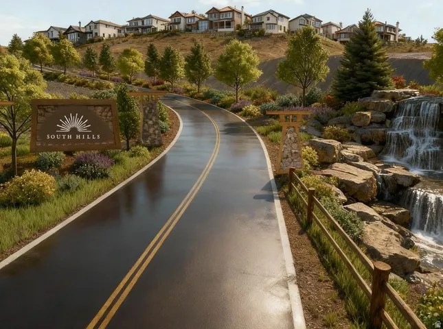 Gated community entrance featuring a custom "South Hills" sign, stone-clad pillars, a paved roadway, and a multi-tiered rock waterfall