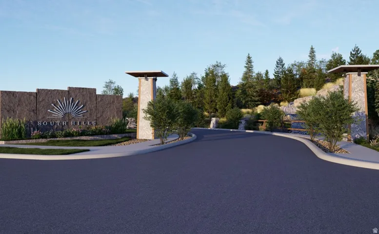Community entrance featuring a stone monument with metallic detailing, integrated landscaping, and a paved roadway