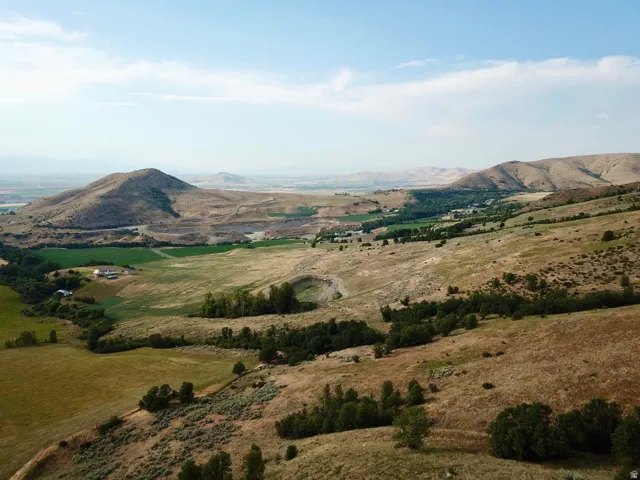 Expansive aerial landscape featuring rolling hills and distant mountains