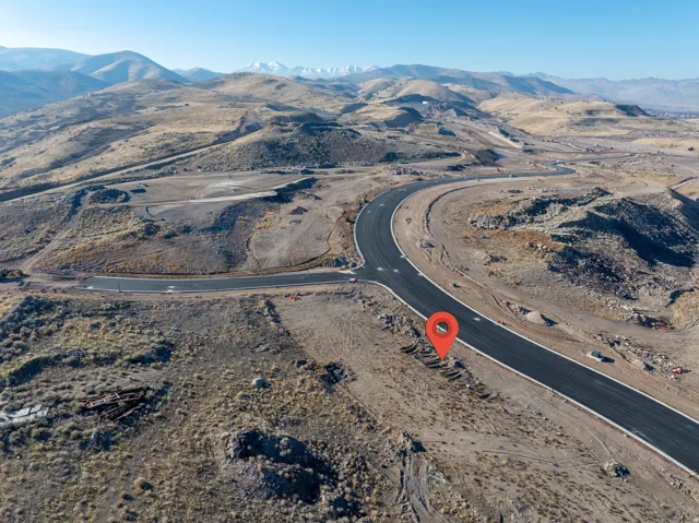 Paved roads traversing undeveloped land with distant mountain ranges under a clear sky