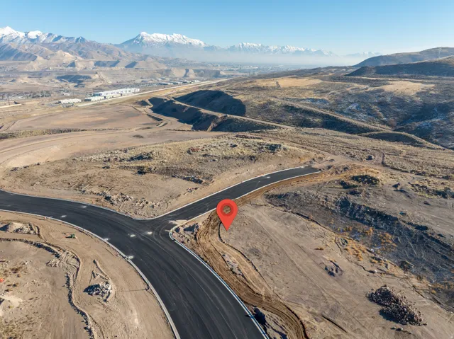 Developing lot with new asphalt paving and curb infrastructure