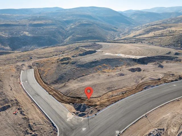 Newly paved roads carving through undeveloped land, with distant mountains forming a natural backdrop