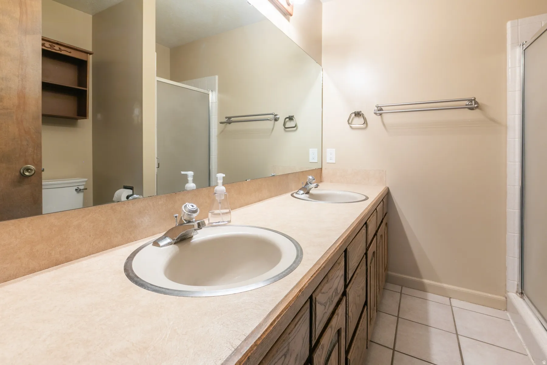 Primary suite bathroom with dual vanity sinks.