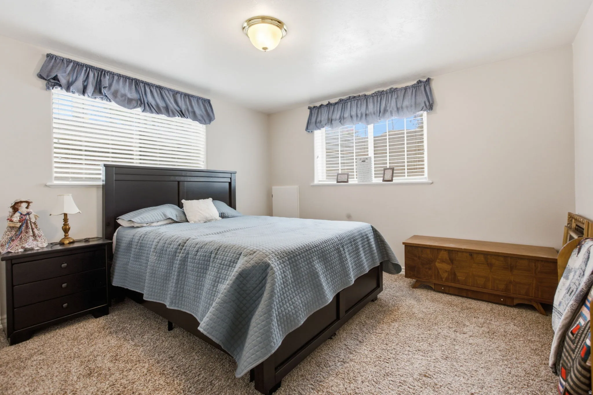 Carpeted bedroom with two windows featuring horizontal blinds