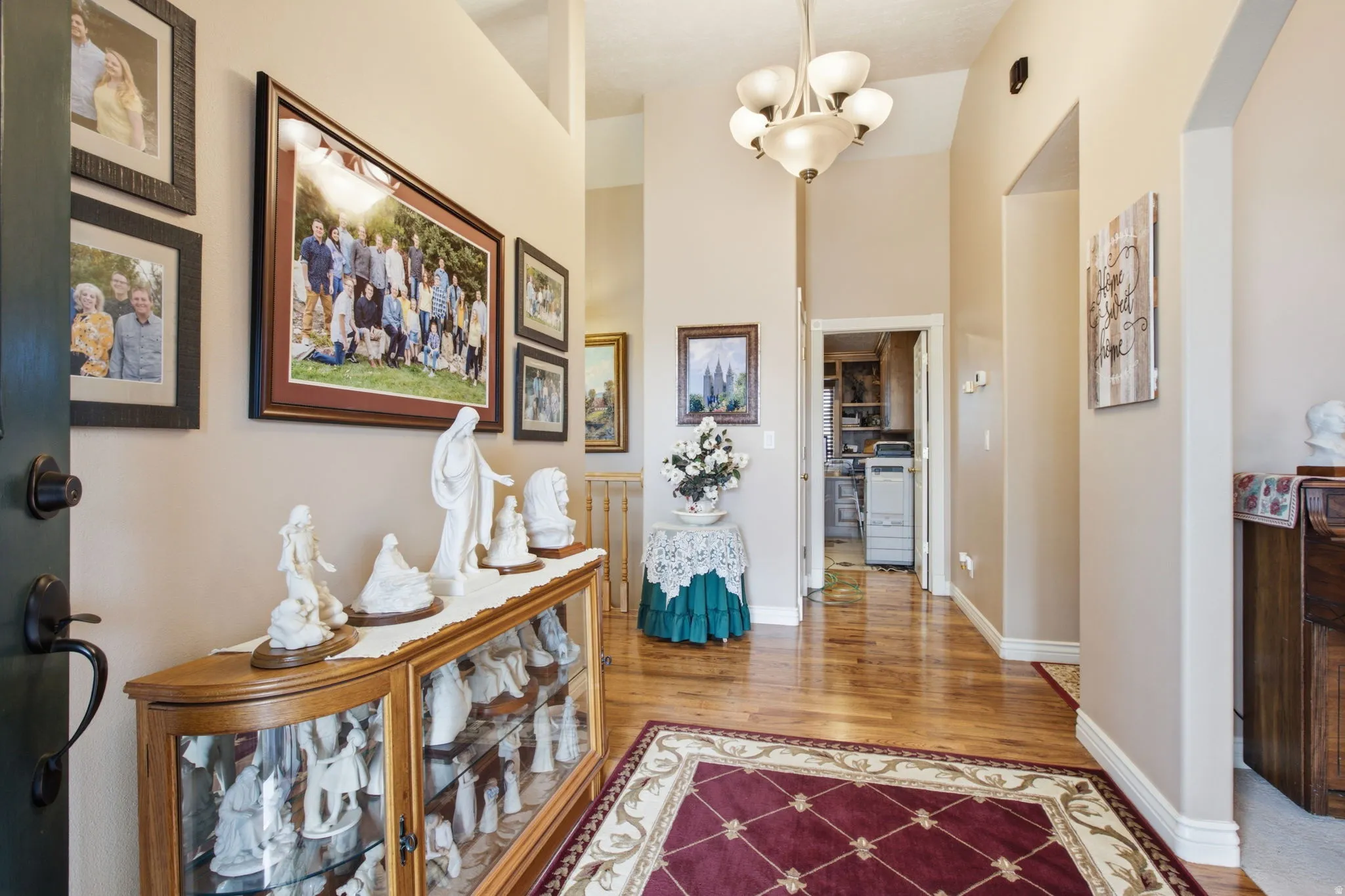 Vaulted entry featuring wood-finish flooring and a decorative chandelier