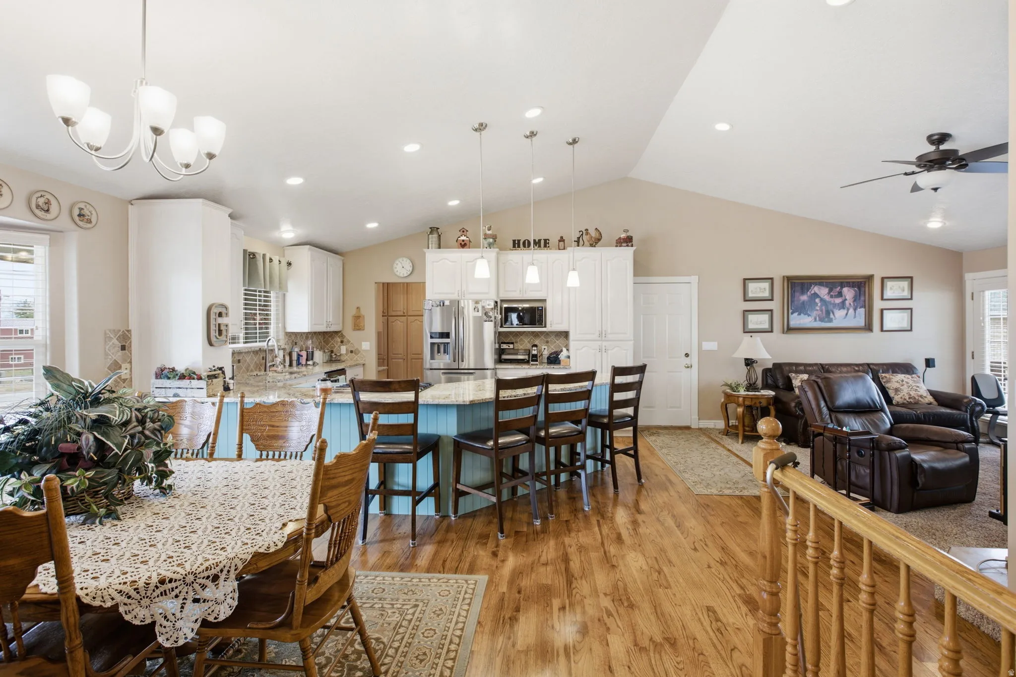 Open-concept living area featuring wood-finish flooring, vaulted ceilings, and recessed lighting