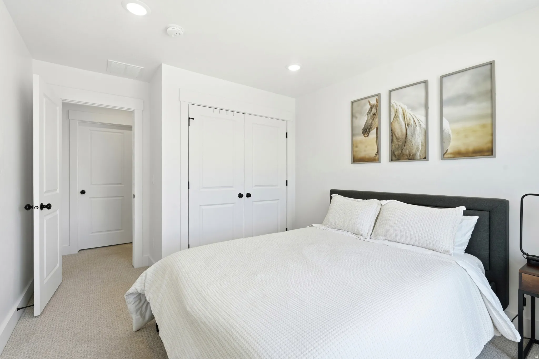Bedroom featuring plush carpeting, recessed lighting, and a double-door closet with black hardware
