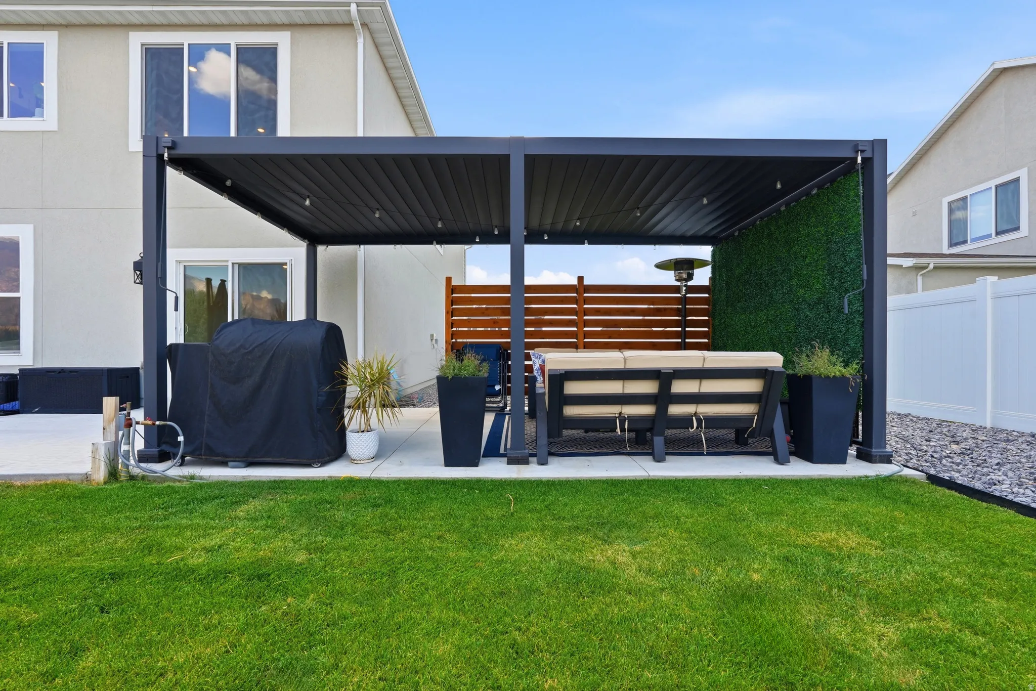 Expansive backyard featuring a lush green lawn and a spacious concrete patio