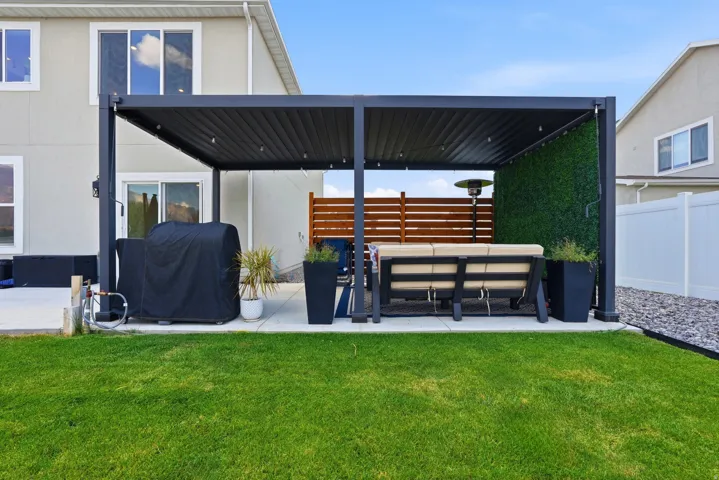 Expansive backyard featuring a lush green lawn and a spacious concrete patio