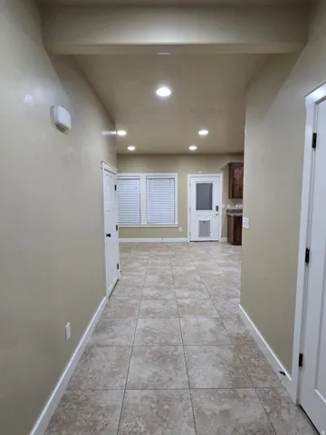 Recessed lighting, tile flooring, interior doors, and multiple windows with blinds