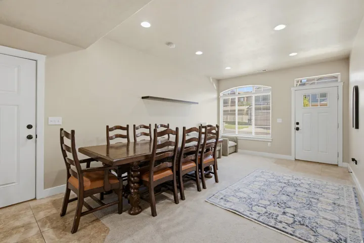 Entryway featuring a paneled door with transom window, recessed lighting, and a large arched window with horizontal blinds