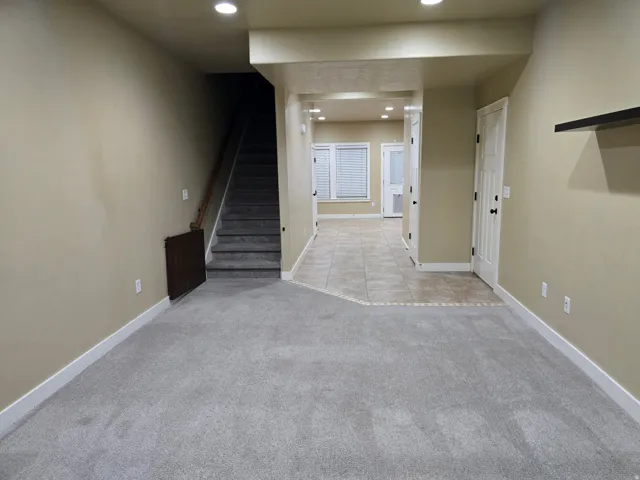 Carpeted flooring, recessed lighting, tile flooring, interior doors, and a built-in wall shelf