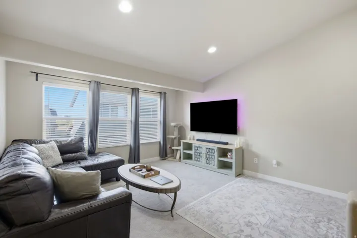 Living area featuring neutral wall tones, recessed lighting, and carpeted flooring