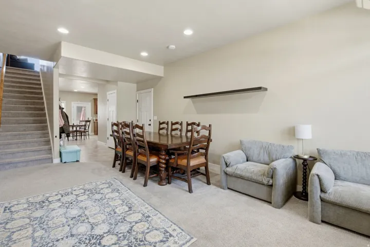 Open-concept living space featuring neutral-toned walls, recessed lighting, and carpeted flooring