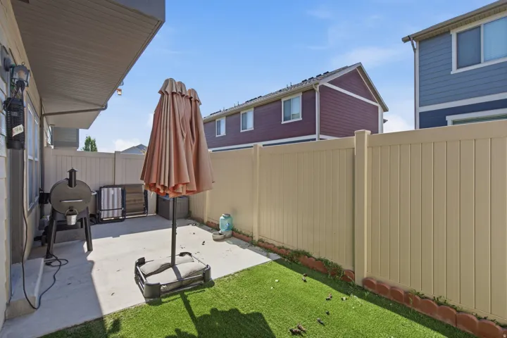 Private concrete patio with an artificial turf area