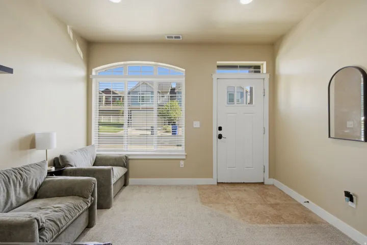 Entryway featuring a white paneled door with window inserts, an arched transom window, and a tile floor landing