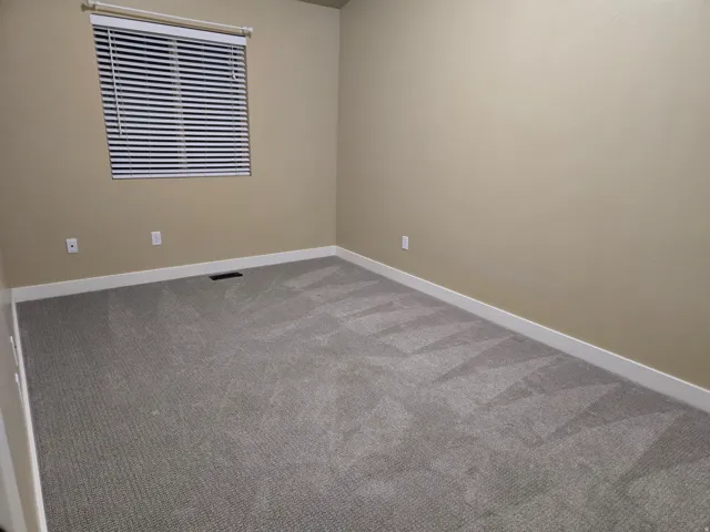 Neutral-toned walls complement the gray carpeting