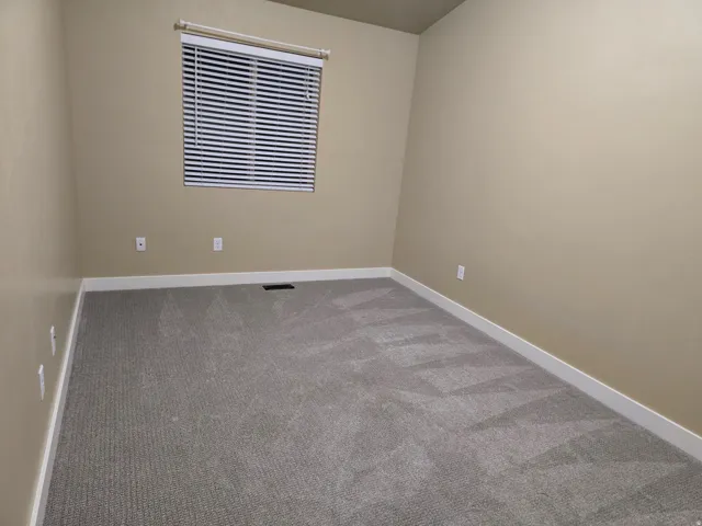 Neutral-toned walls complement the gray carpeted flooring