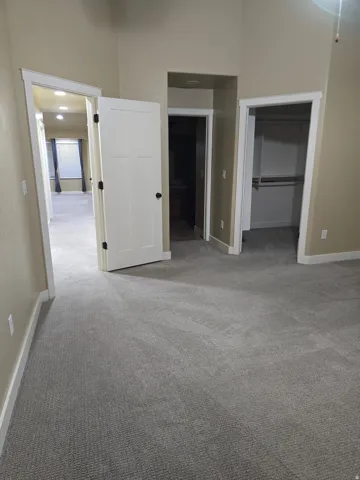 Recessed lighting, light gray carpeting, and neutral wall tones