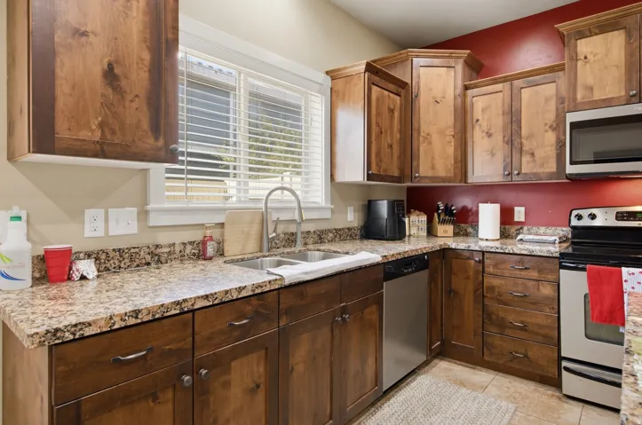 Kitchen featuring wood-finish cabinetry, granite-finish countertops, and stainless steel appliances