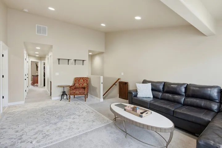 Spacious interior featuring neutral carpeting and a vaulted ceiling