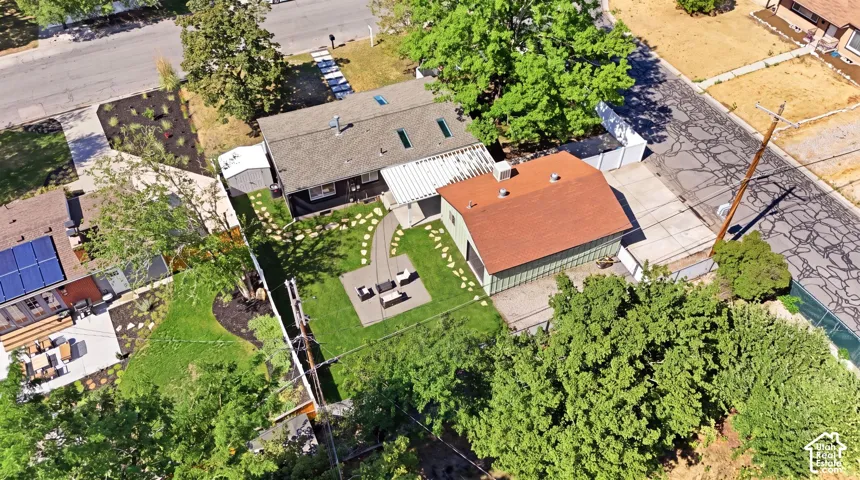 Expansive landscaped backyard featuring a curvilinear stepping stone path, a dedicated patio area, and mature trees providing natural screening