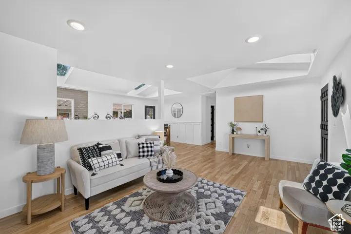 Spacious living area featuring light wood-finish flooring and recessed lighting
