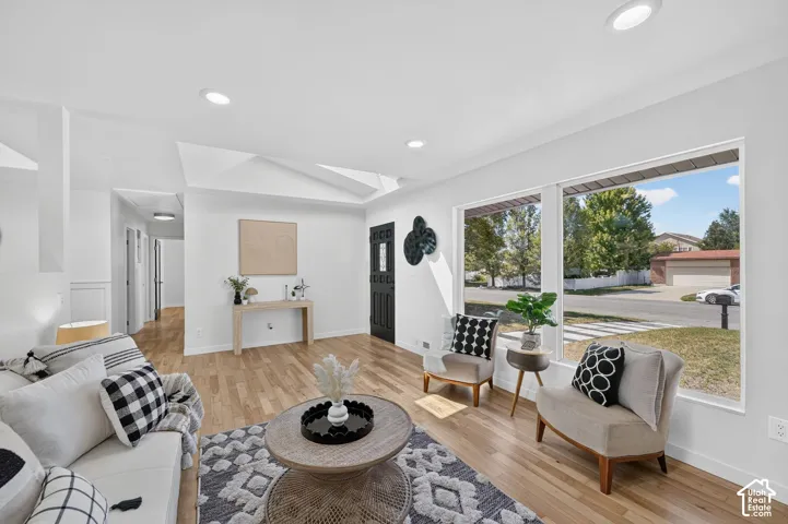Expansive living area featuring wood-finish flooring, recessed lighting, and large picture windows