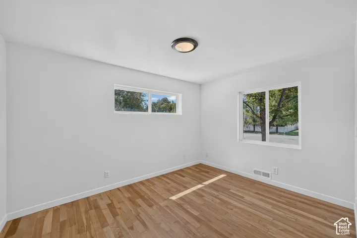 Interior room with light wood-finish flooring, white walls, and white baseboards