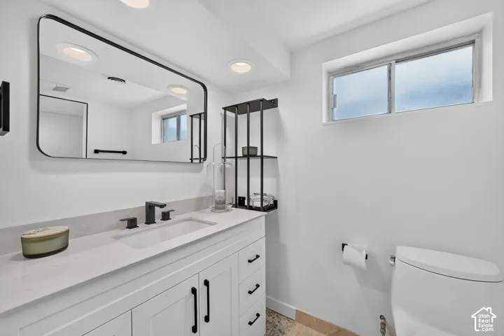 Bathroom featuring a white vanity with panel cabinetry and matte black hardware, a rectangular undermount sink with a matte black widespread faucet, and a large rectangular mirror