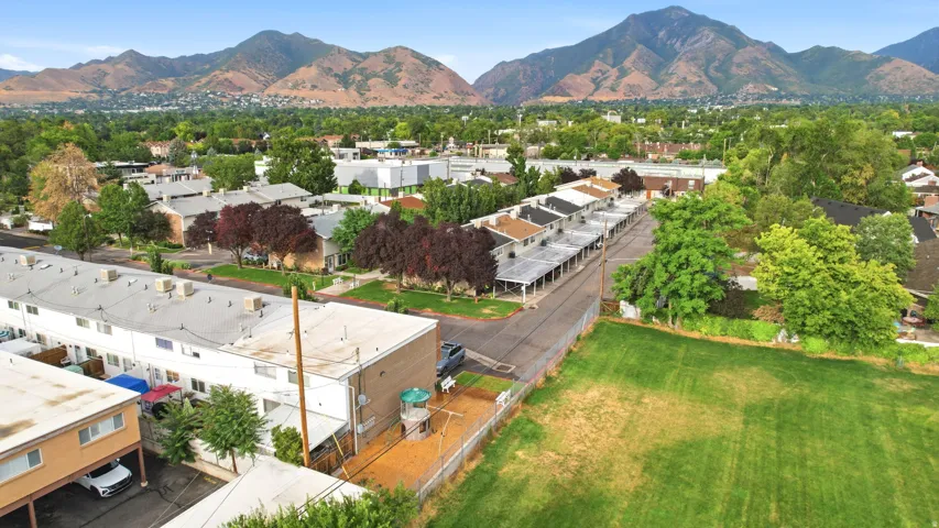 Aerial perspective showcasing multiple two-story residential buildings with flat roofs and a backdrop of verdant mountains