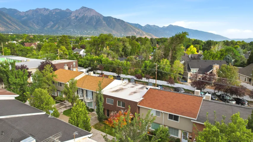 Residential street featuring multiple properties with varied architectural styles and mature trees