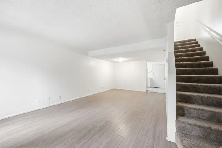Spacious living area featuring light wood-finish flooring and a neutral color palette