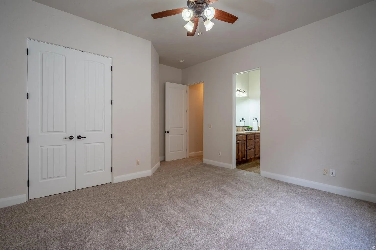 Spacious room featuring neutral carpeting and light wall tones