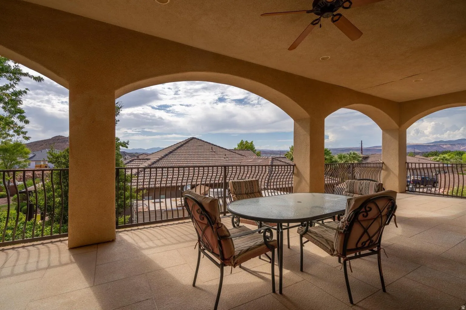Covered balcony featuring arched openings, a ceiling fan, recessed lighting, and tile flooring