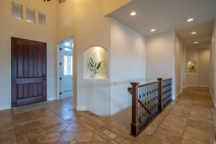 Entryway featuring a wood-panel door, decorative transom windows, and recessed niches with accent lighting