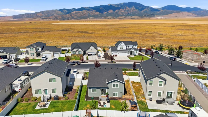 Newly developed residential area featuring various two-story homes with dark shingle roofs and light-colored siding