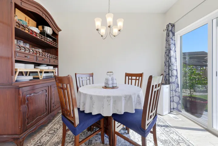 Dining area featuring neutral wall tones, a five-light chandelier, and light-toned flooring