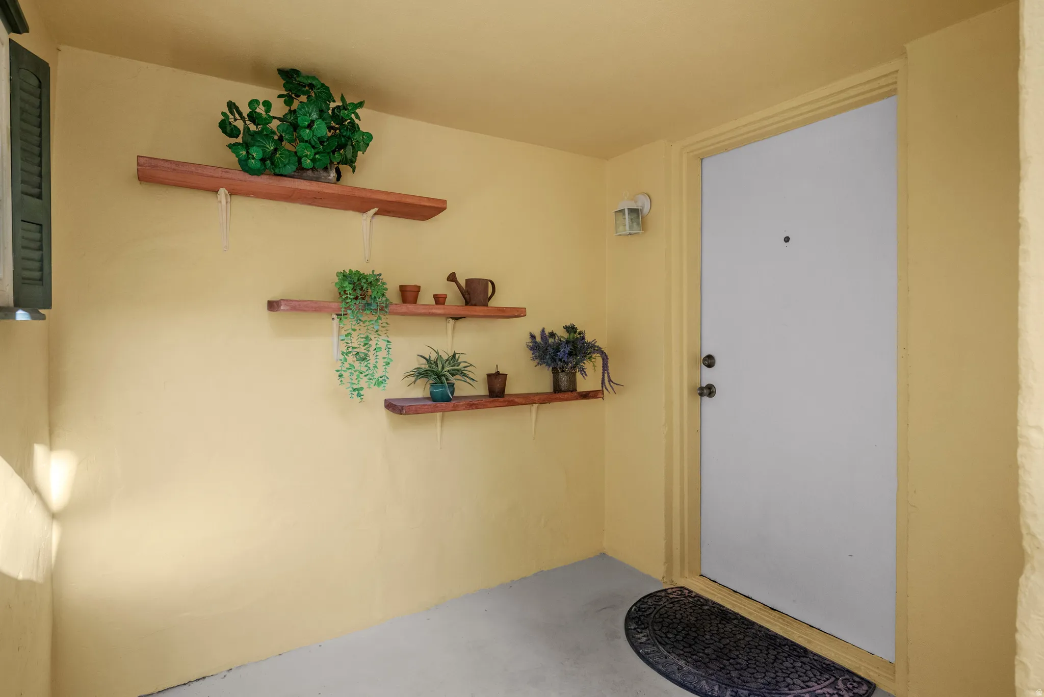 Entryway featuring a solid panel door with a deadbolt, contrasting light yellow walls, and a built-in wall sconce