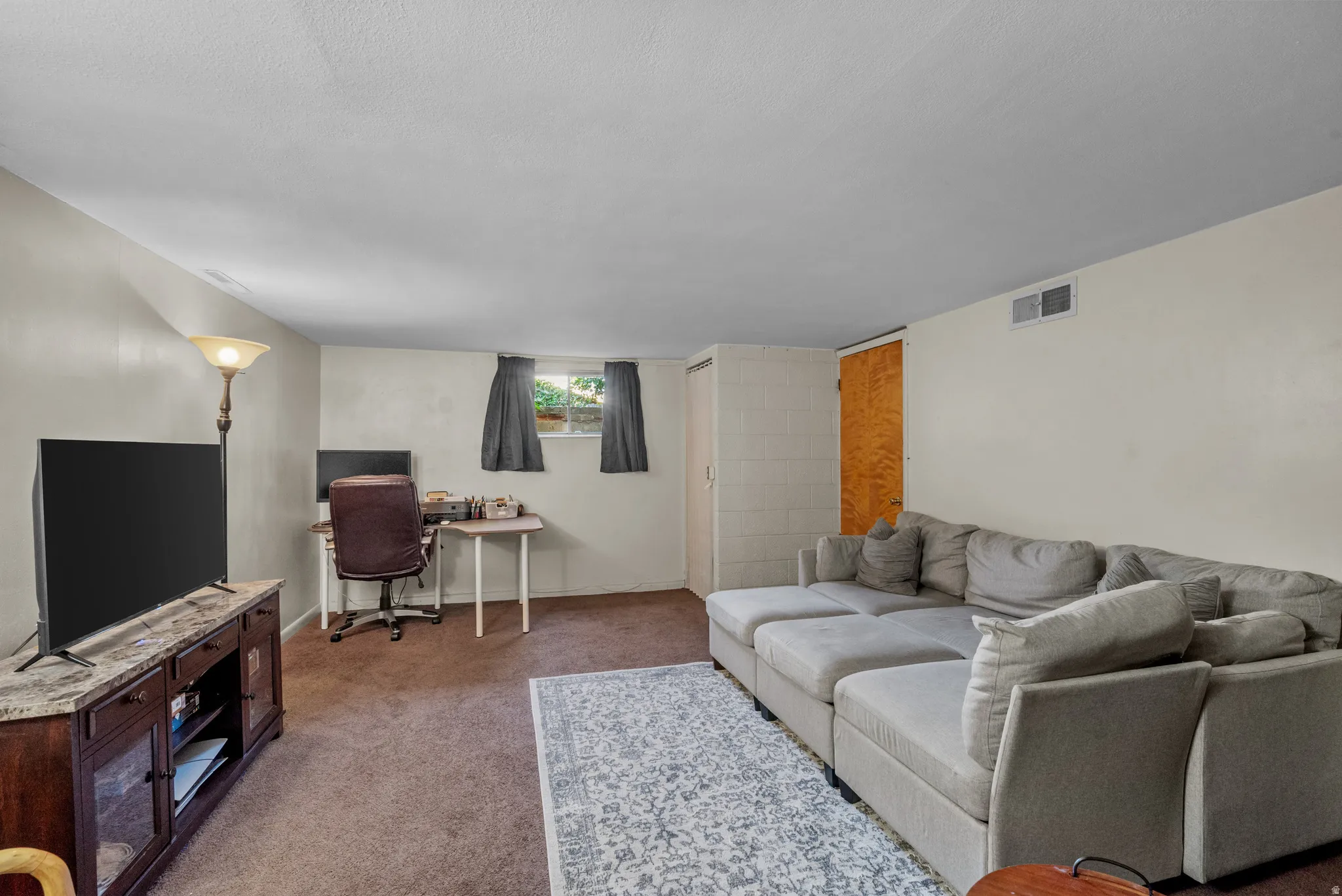 Spacious entertainment area featuring carpeted flooring and light-toned walls