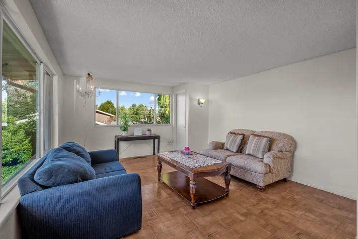 Parquet wood-finish flooring complements abundant natural light from multiple windows
