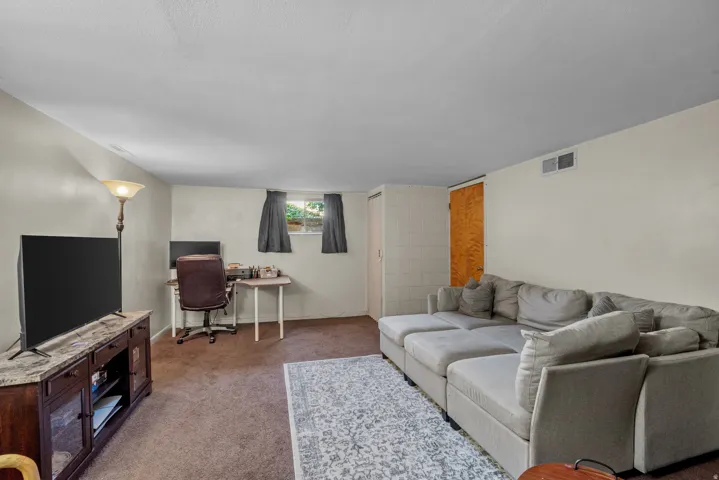 Spacious entertainment area featuring carpeted flooring and light-toned walls