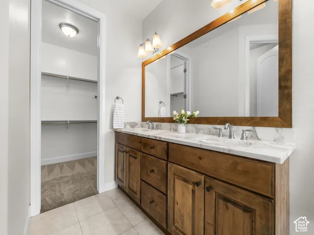 Bathroom featuring a dual vanity with a wood cabinet, white countertop, and individual sinks