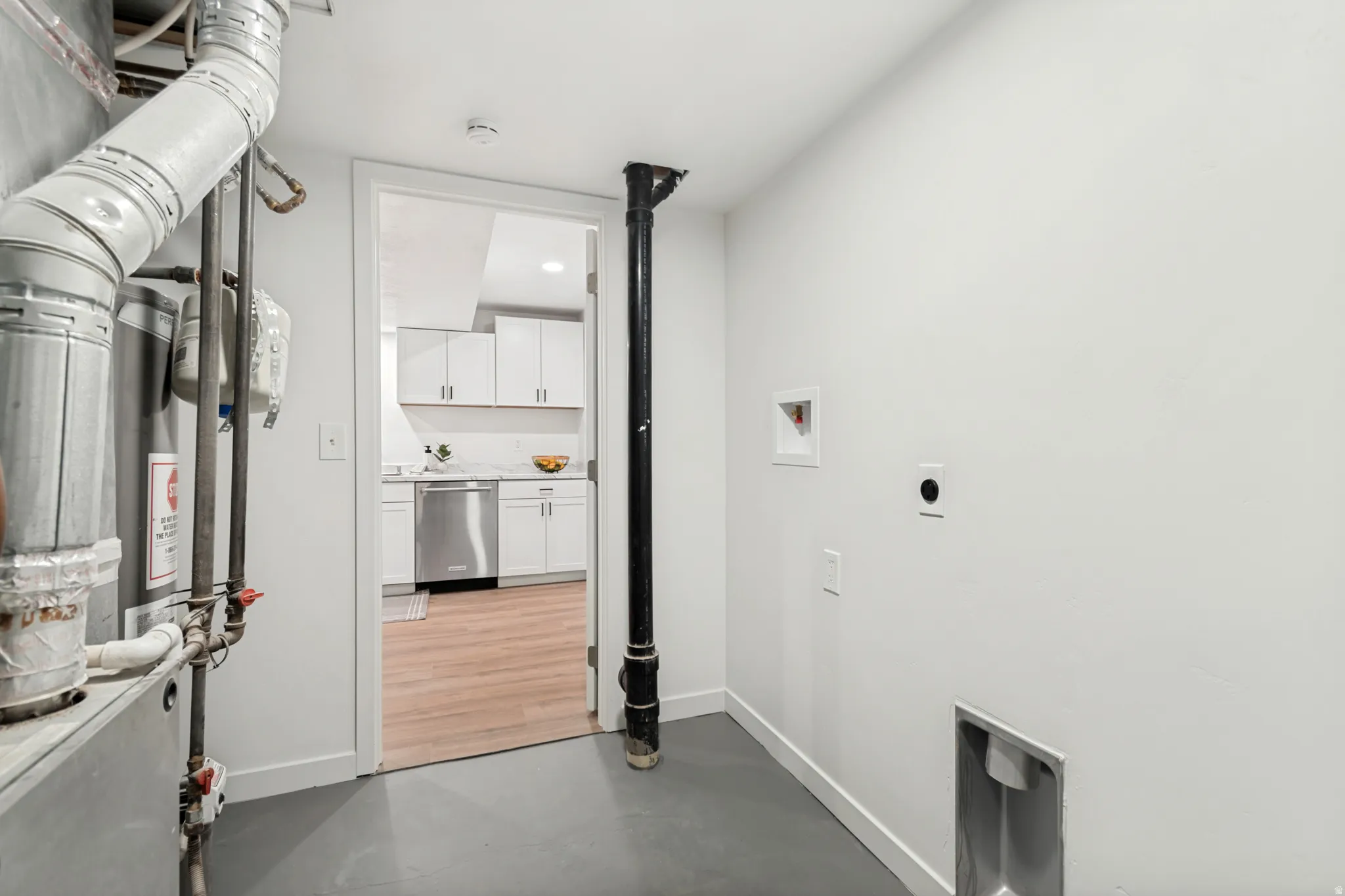 Utility room with white walls and gray flooring