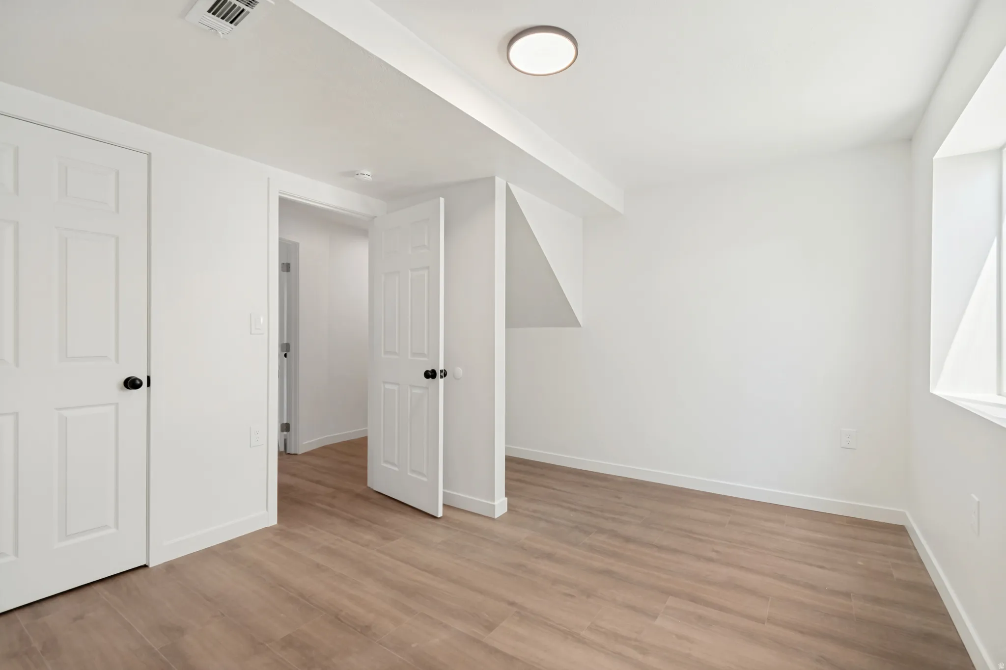 Bright room featuring wood-finish flooring and white baseboards