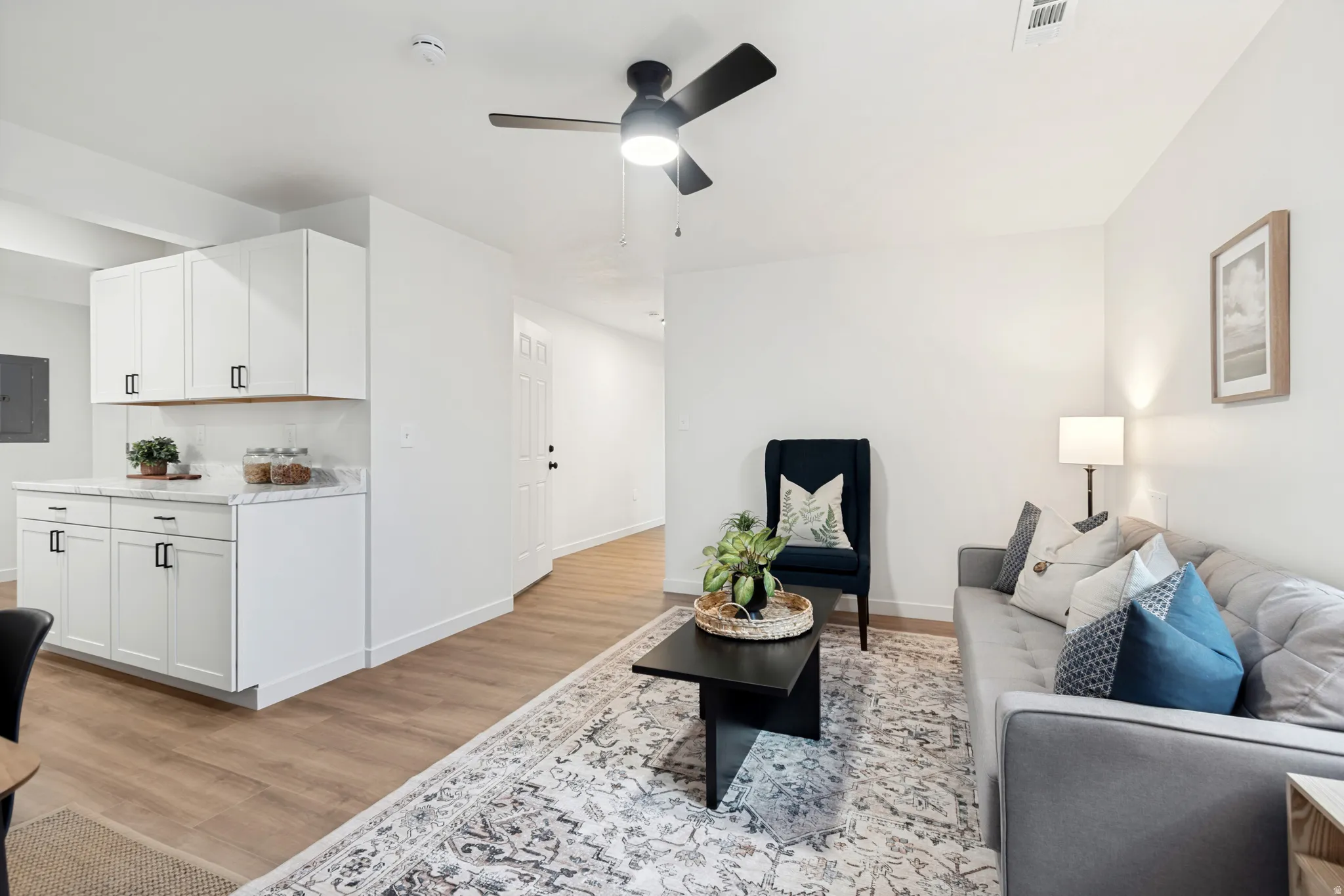 Open-concept living area with wood-finish flooring, recessed lighting, and a ceiling fan