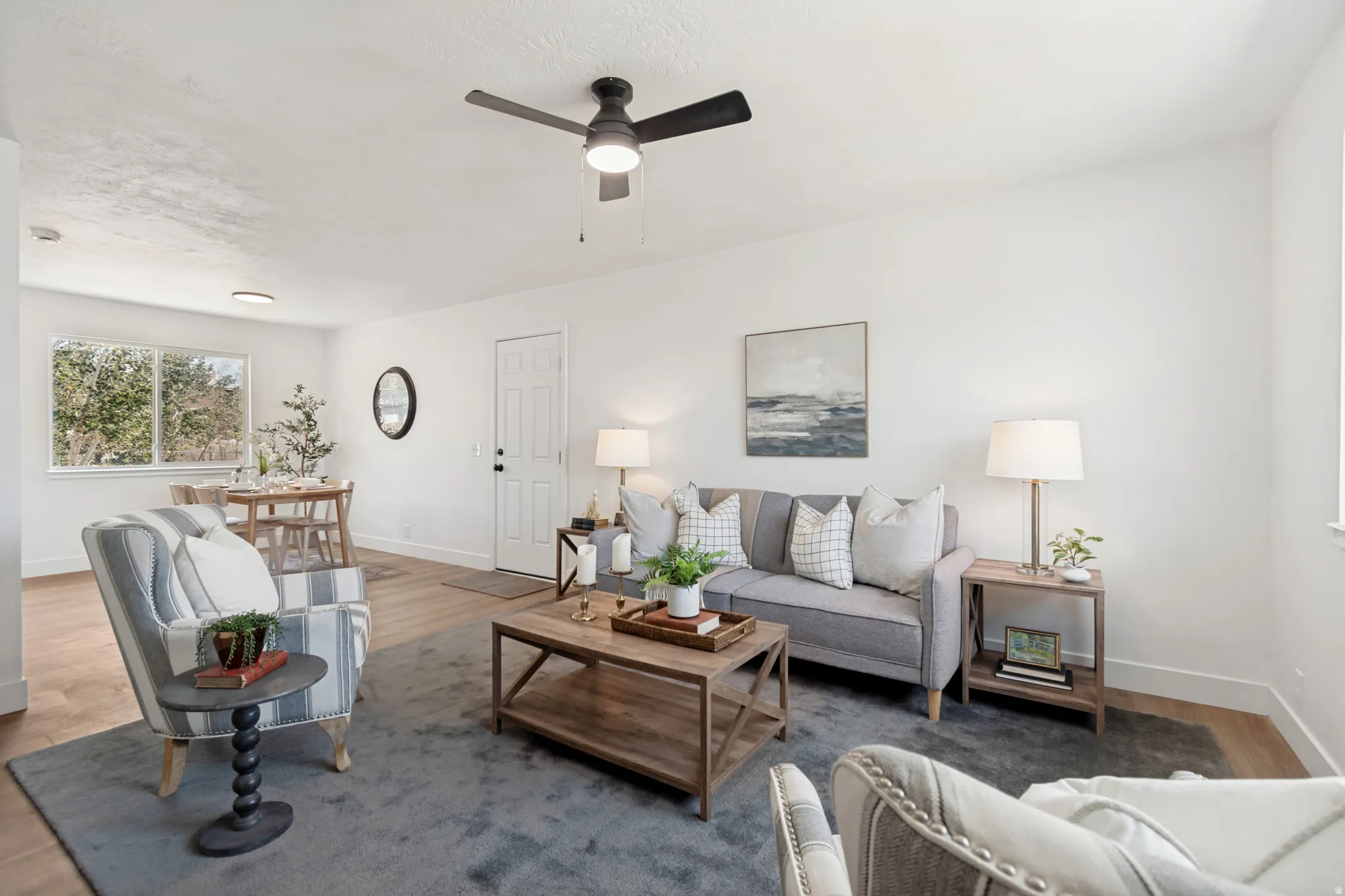 Bright living area featuring wood-finish flooring and a contemporary ceiling fan